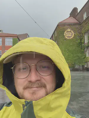 Toivo in front of the KTH building with the KTH logo seen behind him.